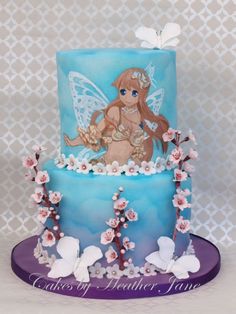 there is a blue cake with a fairy on it