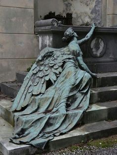 an angel statue sitting on top of steps next to a building