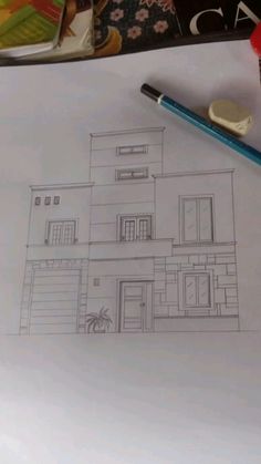 a drawing of a house on top of a piece of paper next to a pencil