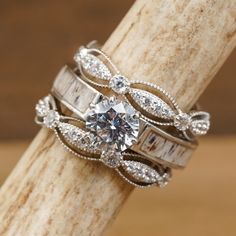 a close up of a ring on top of a wooden stick with a diamond in the middle