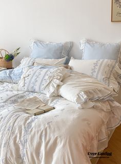 an unmade bed with blue and white linens