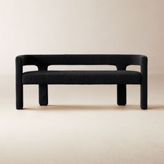 a black bench sitting on top of a white floor next to a beige wall with no one in it