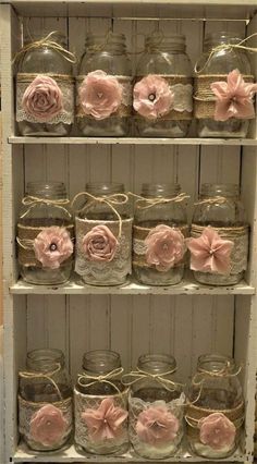 the shelves are filled with glass jars and pink flowers, tied in twine to them