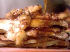 a stack of pancakes covered in syrup and bananas