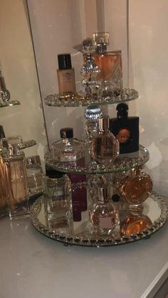 an assortment of perfume bottles on a glass shelf