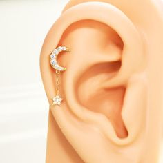 Isn't it the most adorable thing? A little star dangles below the eternally holy moon, and the chain sways gracefully as you move, the dangle helix earring creating a subtle yet aesthetically appealing effect. Come and pair this cute earring with your feminine delicacy. We are stardust; we shall shine forever.