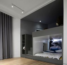 a bedroom with a bunk bed in the middle and curtains on the other side, next to a window