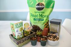 various plants and seeds are sitting on a table next to a bag of sprout moss