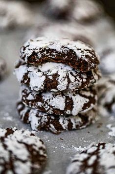 chocolate crinkle cookies piled on top of each other with powdered sugar in the middle