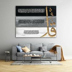 a living room with a couch, coffee table and arabic calligraphy on the wall