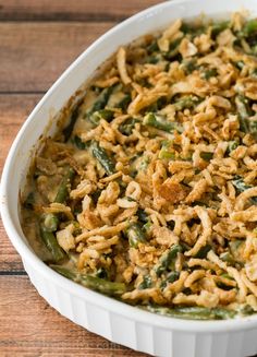 a casserole dish filled with green beans and rice on a wooden table top