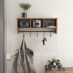 a coat rack with two coats hanging from it's sides and a bag on the other side