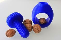 there is a blue vase with nuts in it and one nut on the ground next to it