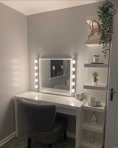 a desk with a chair, mirror and potted plant on it in a room