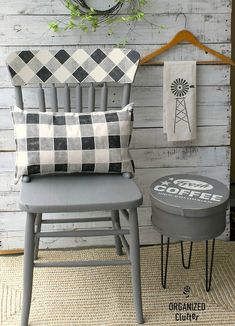 two chairs and a stool in front of a wall with a clock on the side