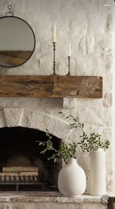 a white vase sitting on top of a fireplace