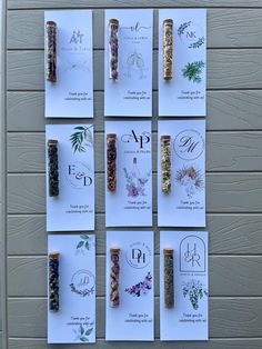 several different types of herbs are displayed on the wall next to each other with cards attached