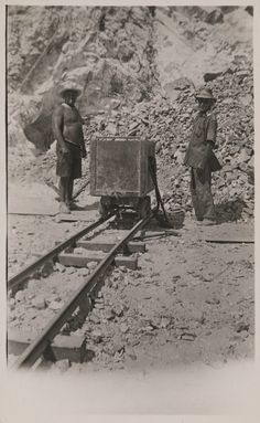 two men standing next to each other on train tracks