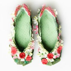 pair of green slippers with flowers on them