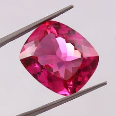 a pink diamond sitting on top of two needles