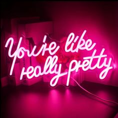 a pink neon sign that says you're like really pretty on top of a table