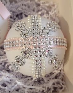 an ornament in a box decorated with pearls and crystals, is shown here