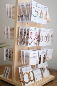 there are many different types of earrings on the display rack with price tags attached to them