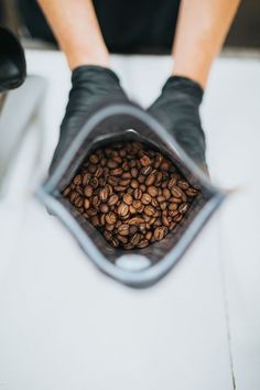 a person holding a bag full of coffee beans