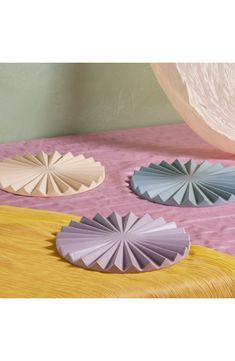 three paper fans sitting on top of a bed