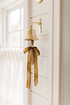 a bell hanging from the side of a white wall