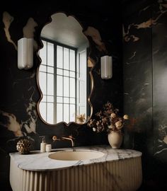 a bathroom with a marble sink and large mirror