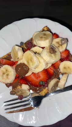 a white plate topped with bananas and strawberries