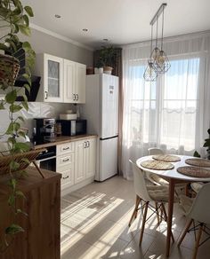 a kitchen filled with lots of white appliances and furniture next to a dining room table