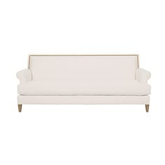 a white couch sitting on top of a white floor next to a wooden leg chair