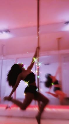 a woman is dancing on a pole in the air