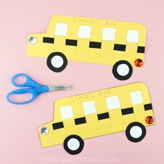 two school bus cut out from construction paper with scissors next to them on a pink background