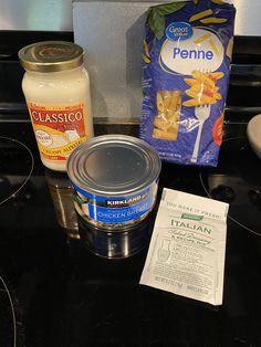 ingredients to make pasta sitting on top of a black stove burner with a packet of penne next to it