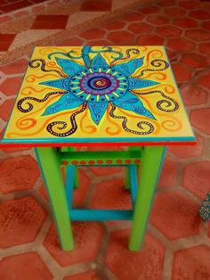 a brightly colored table sitting on top of a brick floor