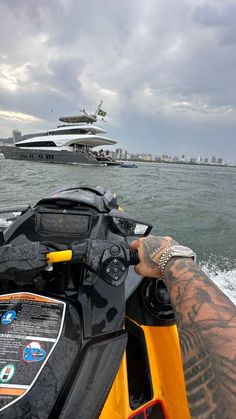 a man riding on the back of a yellow and black jet ski in the ocean