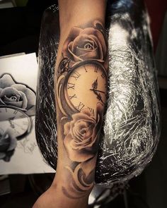 a woman's arm with a clock and roses tattoo on it