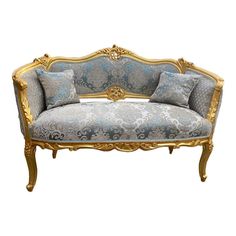 an ornate gold and blue couch with pillows on it's back end, against a white background