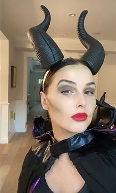 a woman with horns on her head and red lipstick