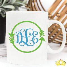 a coffee mug with an arrow and the word monogrammed in blue on it