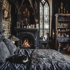 a cat is laying on a bed in front of a fire place and bookshelf