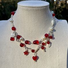 "Silver wire and chains. Really pretty red glass beads, including hearts and stars. Also includes a couple cream colored hearts throughout  15\" long Shipping is free on all necklaces. They're all handmade by me, most including upcycled and vintage beads. It's best to keep out of water. If you want an extender and the necklace doesn't have one, just message me and I'll add one for you:) I can also make the extender longer." Luxury Heart Beads Necklace For Valentine's Day, Diy Heart Necklace, Red Handmade Necklace, Handmade Red Dangle Charm Necklaces, Red Handmade Dangle Charm Necklaces, Red Beaded Whimsical Jewelry, Whimsical Red Beaded Jewelry, Red Necklace Beads, Necklace Inspo Beads