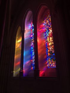 two stained glass windows in a church with sunlight streaming through them and the light coming through them