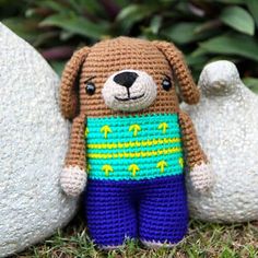 a crocheted dog is standing next to two large white balls in the grass