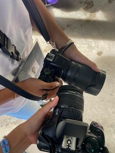 a person holding a camera in their hand with other cameras around her and the photographer taking pictures