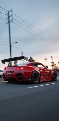 a red sports car driving down the road