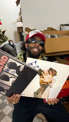 a man holding up some records in his hands